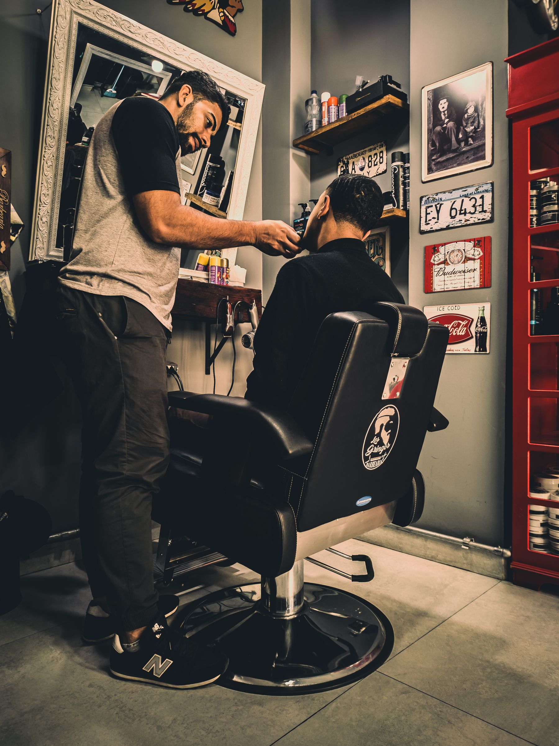 A barber working a fresh skin fade in the chair