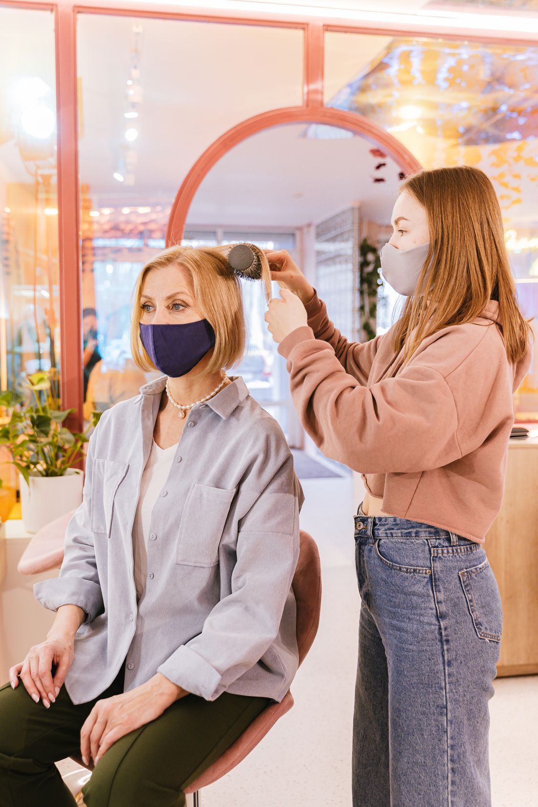Stylist blow-drying and styling a client's hair at Lumi&egrave;re salon