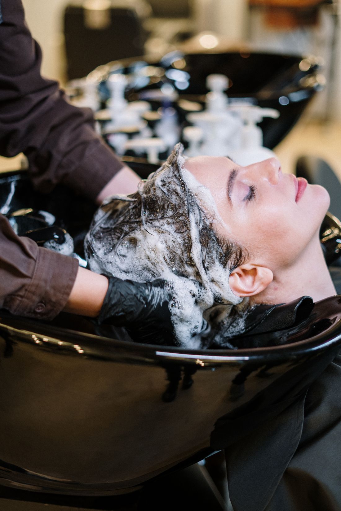 Client having their hair washed at the basin before a treatment