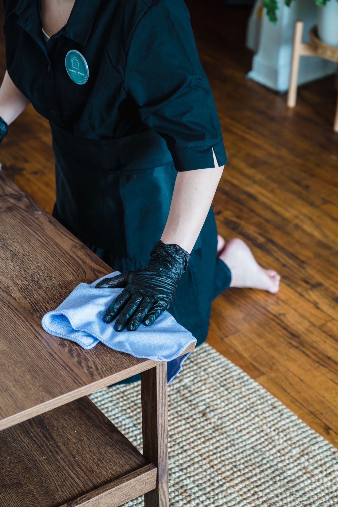 Gloved hands wiping and sanitising a table surface